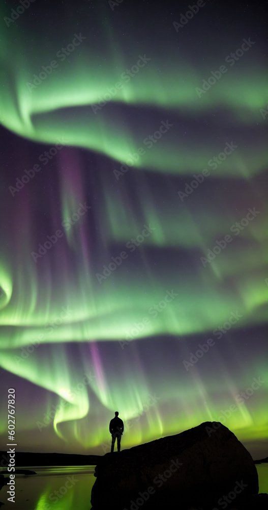  silhouette of a man stands resolute on a rugged rock, his eyes fixed upon the night sky.  transcendent journey as you witness the display of the northern lights, aurora borealis. Generative AI