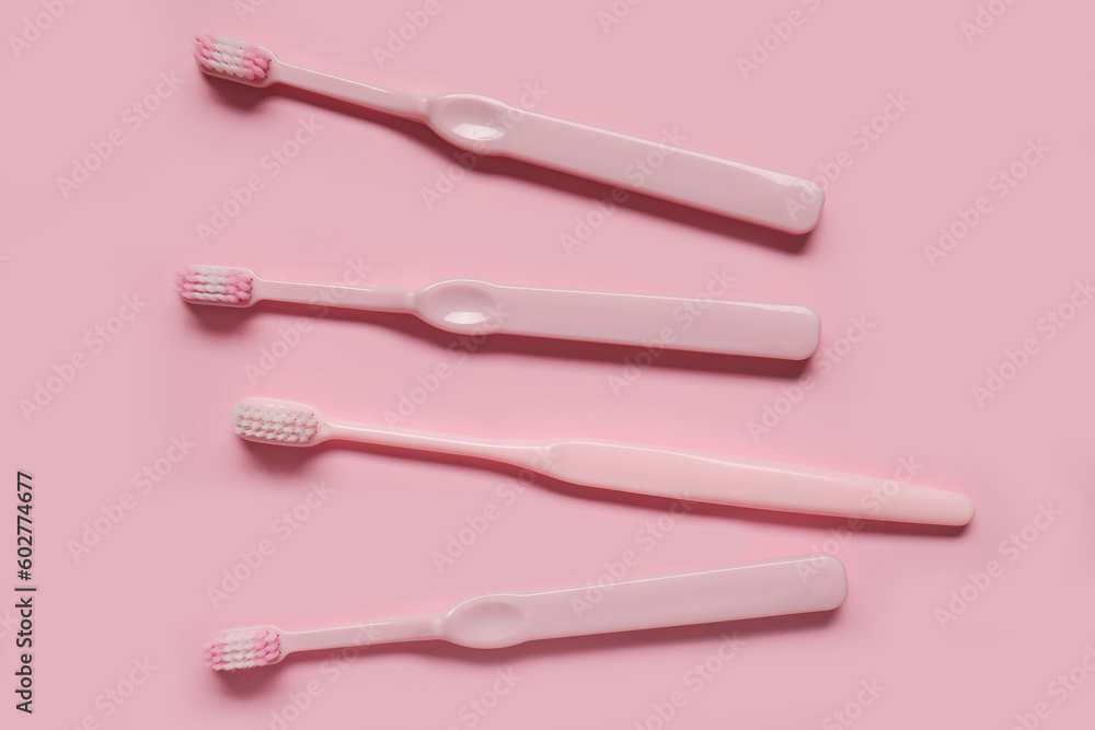 Plastic toothbrushes on pink background Plastic toothbrushes on pink background