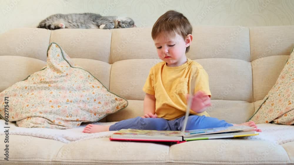 The cute baby is playing with the colorful picture book, flipping through the pages and touching the pictures. The serious little child is lost in thought as he reads book while sitting at home. The cute baby is playing with the colorful picture book, flipping through the pages and touching the pictures. The serious little child is lost in thought as he reads book while sitting at home.