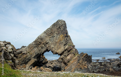 Pyramid shaped rock formation on the east coast of Scotland in the North Sea with beautiful blue sky and seascape 