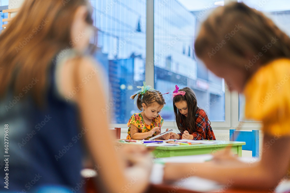 Creative kids during an art class in a daycare center or elementary school classroom drawing with female teacher. Creative kids during an art class in a daycare center or elementary school classroom drawing with female teacher.