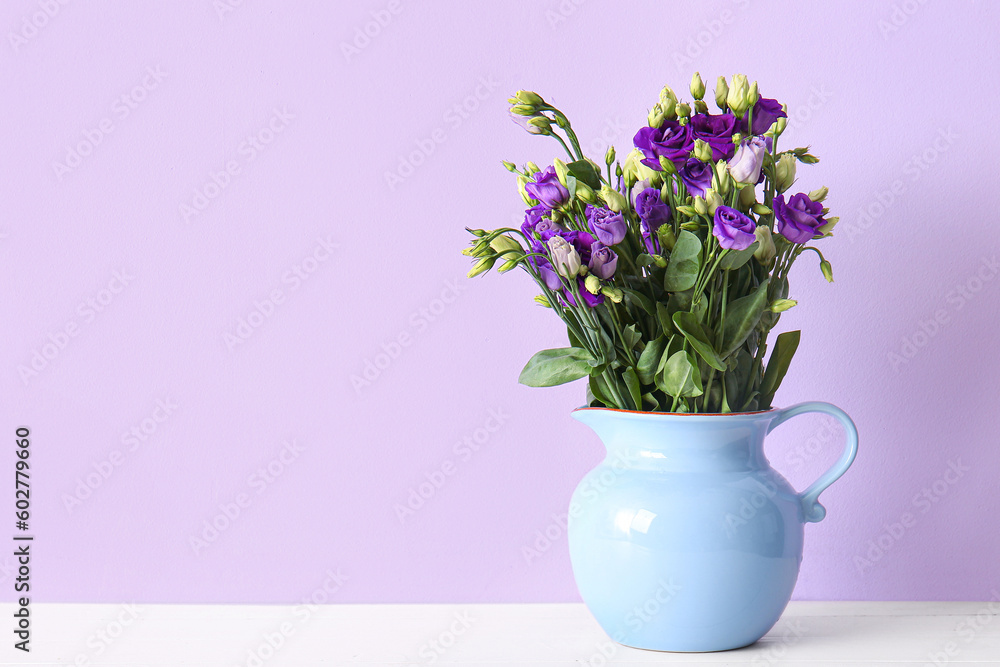 Jug with eustoma flowers on table near lilac wall Jug with eustoma flowers on table near lilac wall