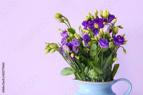 Jug with eustoma flowers on lilac background