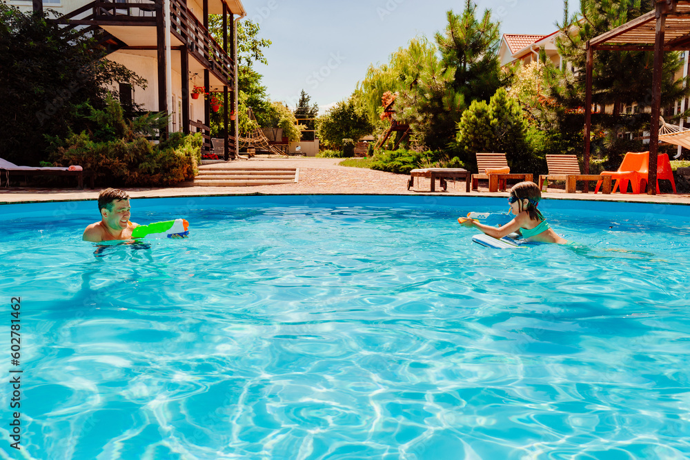Father and daughter have fun with water guns in the pool. Father and daughter have fun with water guns in the pool.