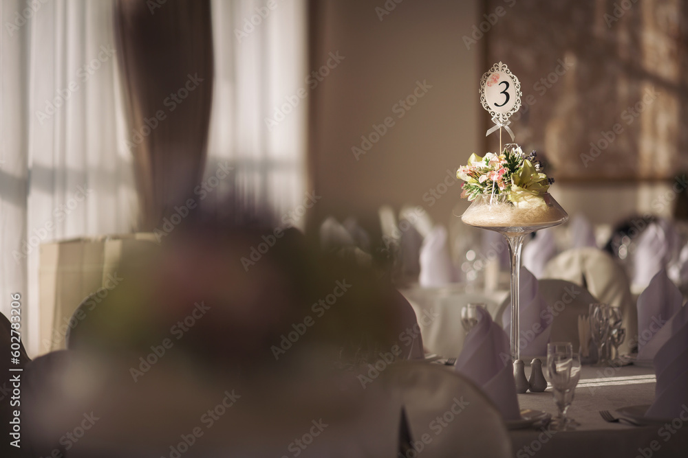 Wedding. Banquet. The chairs and round table for guests, served with cutlery, flowers and crockery and covered with a tablecloth. Stylish wedding decor for a classic wedding in pastel shades.