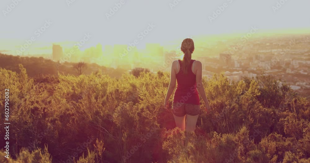 Hiking, sunset and city with woman in mountains for relax, adventure and environment. Summer, plant and freedom with girl standing in field for travel destination, discovery and trekking journey Hiking, sunset and city with woman in mountains for relax, adventure and environment. Summer, plant and freedom with girl standing in field for travel destination, discovery and trekking journey