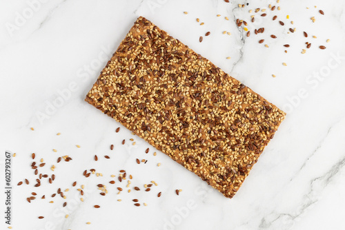 Tableau sur toile Crispy whole cereal bread with flax and sesame seeds on white marble background