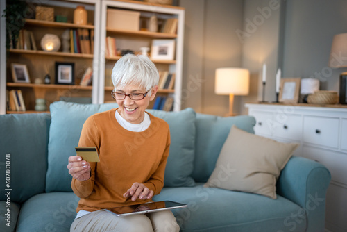 Senior woman caucasian female hold credit card online shopping at home