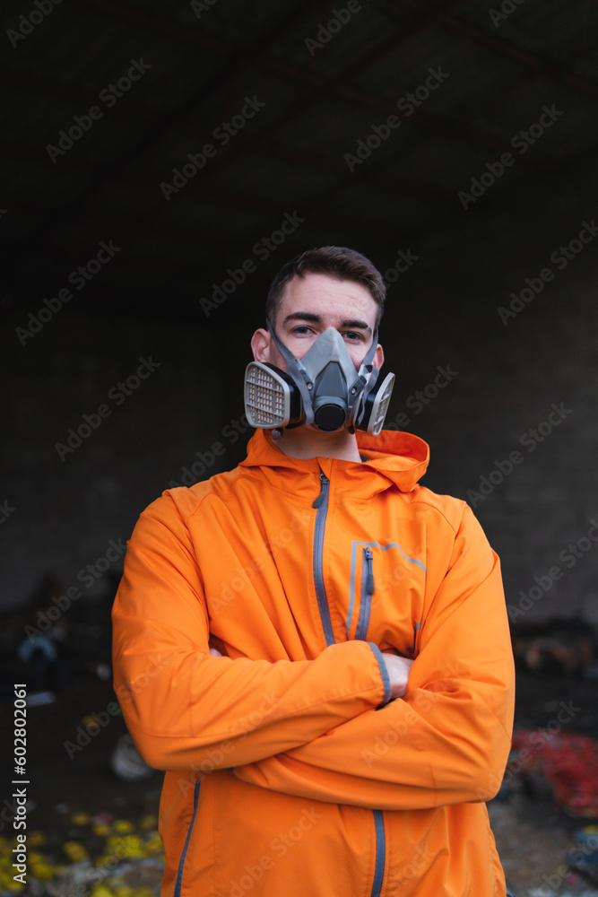 One young guy drawing graffiti on wall with spray can and mask on his face during the day
One young guy drawing graffiti on wall with spray can and mask on his face during the day