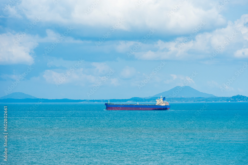 Cargo container ship sailing through peaceful, calm, blue sea on her voyage through the Singapore Strait. 