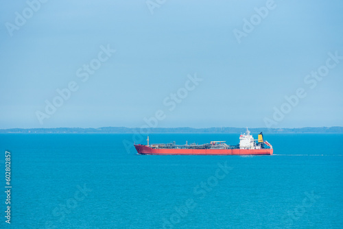 Cargo ship, oil tanker, sailing through peaceful, calm, blue sea on her voyage through the Singapore Strait. 