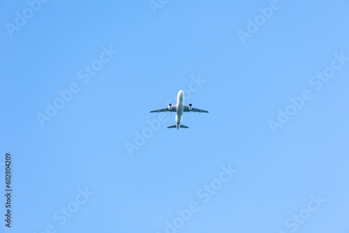 A jet plane flying in a blue sky between clouds. Transportation. Air travel.