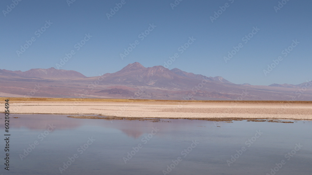 Lago de sal no meio do deserto do Atacama com visão do vulcão ao fundo ...