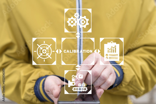 Engineer using smartphone and virtual touch screen sees text: CALIBRATION. Concept of activate calibration, intermediate check or calibration measurement. Mobile calibration operations.