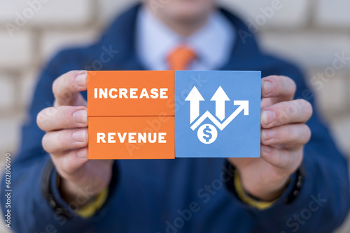 Man holding colorful blocks with icons and inscription: INCREASE REVENUE. Concept of growth hacking and increase revenue marketing business technology. Increase number of users and revenues. photo