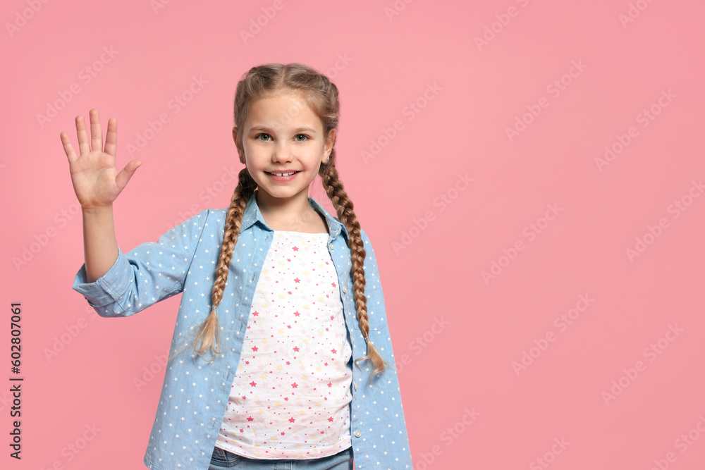 Cheerful girl giving high five on pink background, space for text Cheerful girl giving high five on pink background, space for text