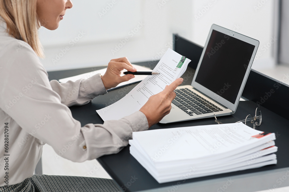Businesswoman working with documents at grey table in office, closeup Businesswoman working with documents at grey table in office, closeup