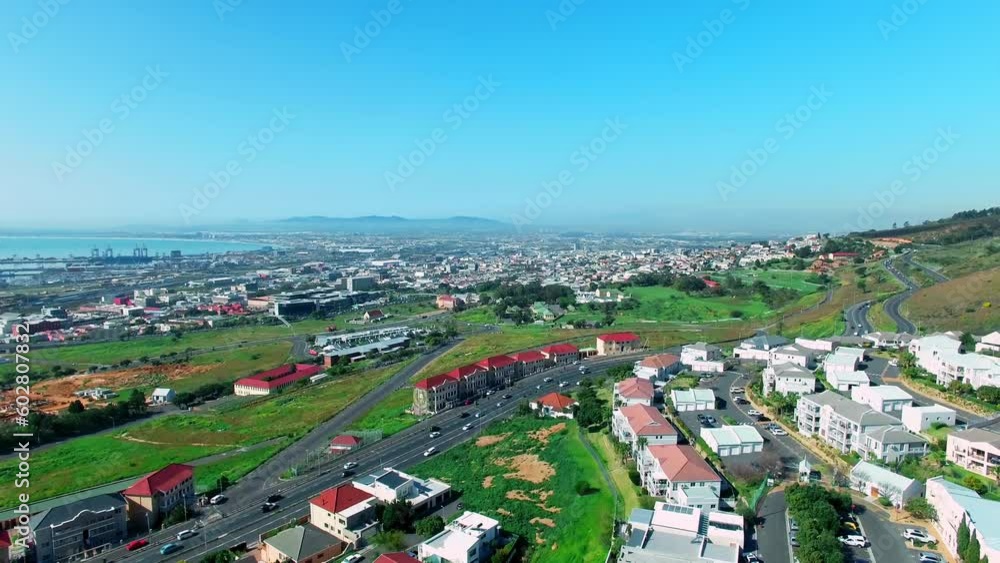 Architecture, buildings and house with drone of city in Cape Town for traffic, highway and road. Blue sky, mountains and travel in aerial view of grid with infrastructure, cityscape or cars in street