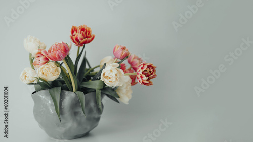 White summer tulips in a modern grey vase on a table at home. Mock-up for displaying works