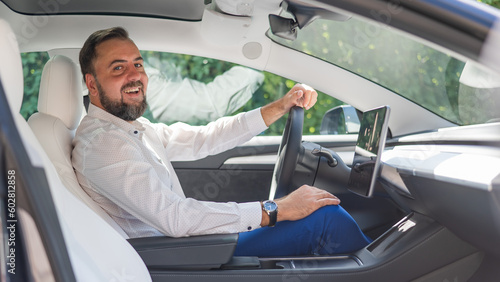 Caucasian bearded man in a suit driving a car.  © Михаил Решетников