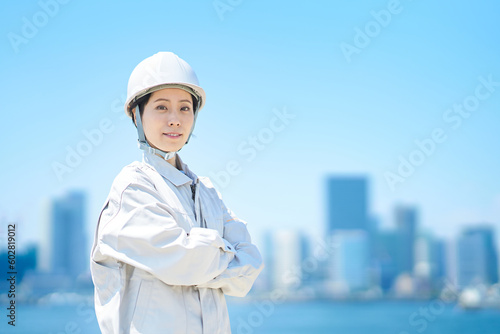 ヘルメットを装着して作業着を着た女性