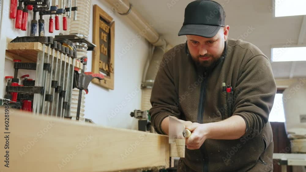 Caucasian carpenter using a tenon saw and cutting wood in his workshop, medium shot. High quality 4k footage Caucasian carpenter using a tenon saw and cutting wood in his workshop, medium shot. High quality 4k footage
