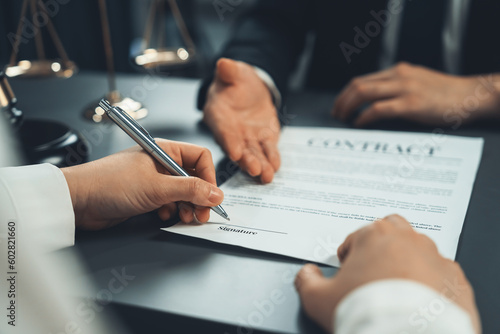 Fotografiet Closeup businessman sign contract or legal document with pen in his hand during corporate meeting for business deal or legal executive decision to pay off a loan or filing for bankruptcy