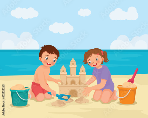 Cute kids building sand castle having fun on the beach on summer holiday