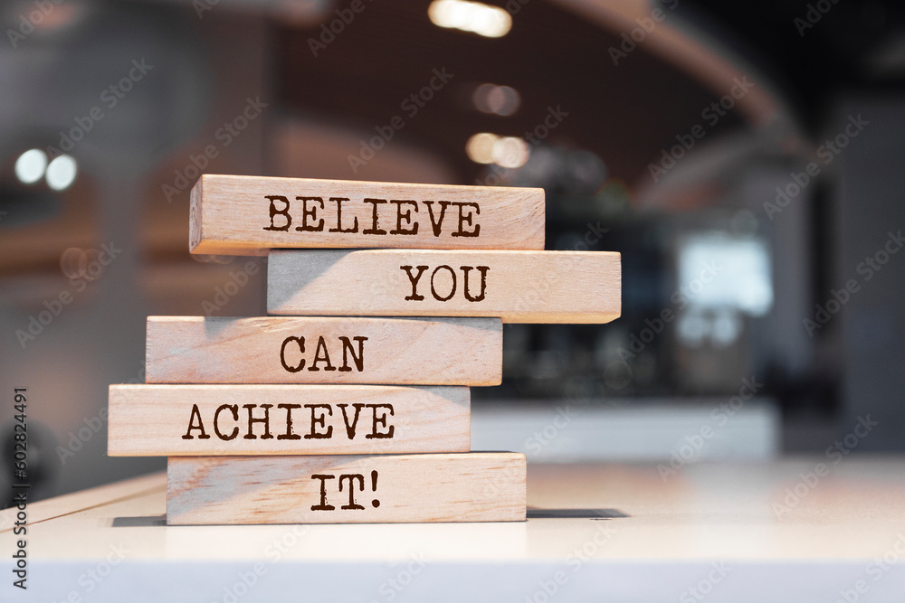 Wooden blocks with words 'Believe you can achieve it'.