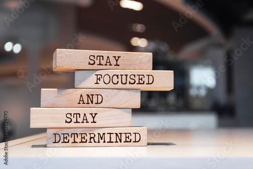 Wooden blocks with words 'Stay focused and stay determined'.