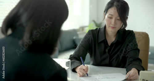 밝은미소를 지으며 계약서에 사인을 하는 고객