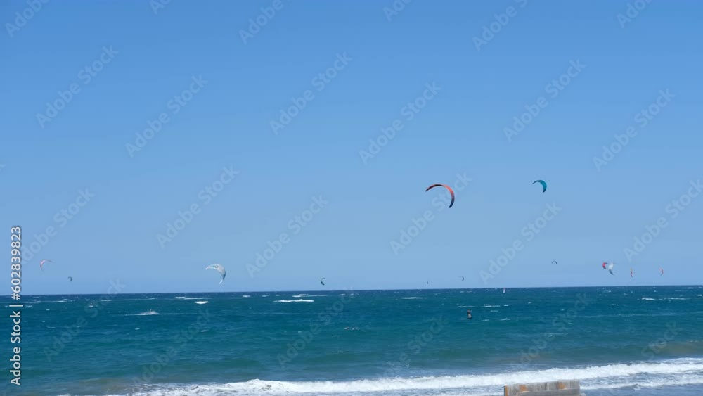 Panoramic sea view with kitesurfing sails. people enjoy riding a kitesurfing board on a bright sunny day, by the sea or ocean. Water sports, adrenaline, fun, adventure Panoramic sea view with kitesurfing sails. people enjoy riding a kitesurfing board on a bright sunny day, by the sea or ocean. Water sports, adrenaline, fun, adventure
