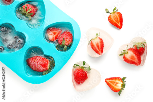 Fototapeta Naklejka Na Ścianę i Meble -  Ice tray with fresh berries frozen in ice on white background