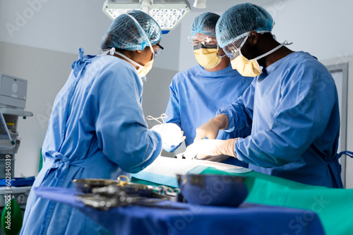 Diverse group of surgeons operating on patient in operating theatre