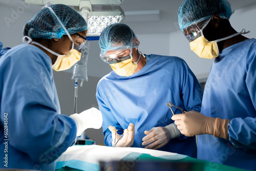Diverse group of surgeons operating on patient in operating theatre