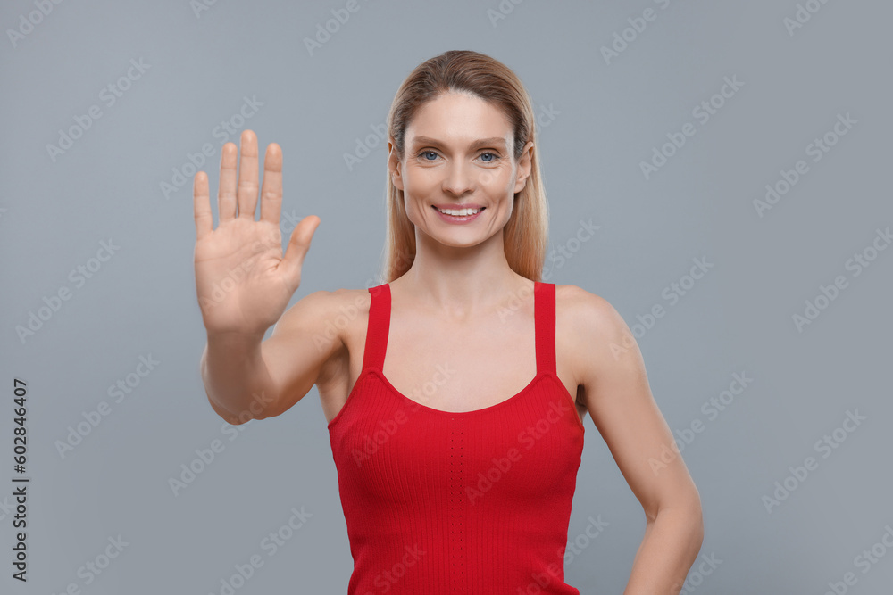 Woman giving high five on grey background Woman giving high five on grey background