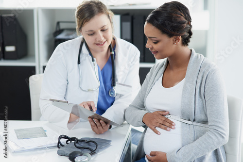 Talking, results and a doctor with a pregnant woman during a consultation for progress on a baby. Communication, smile and a hospital worker speaking to a patient about healthcare during a pregnancy photo