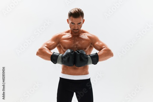 Man athletic bodybuilder poses in boxing gloves with nude torso abs in full-length background, boxing and martial arts. Advertising, sports, active lifestyle, competition, challenge concept. 