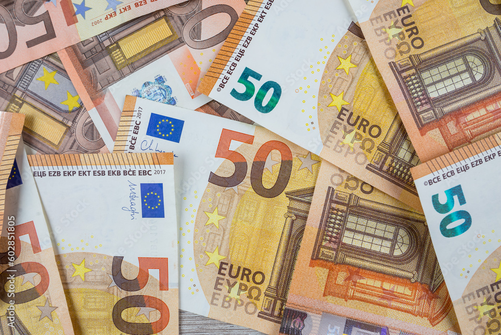 Obraz premium Pile of banknotes on the table in denominations of fifty euros.