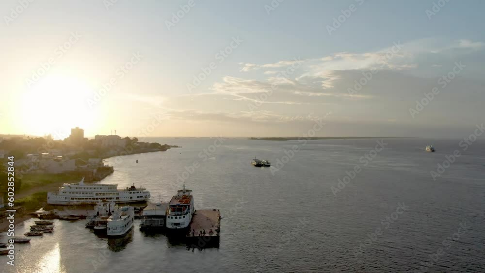 Aerial view passing river boats docked on the coast of Santarem, sunset in Brazil Aerial view passing river boats docked on the coast of Santarem, sunset in Brazil