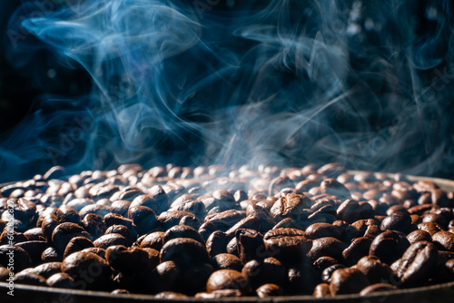 Coffee beans roasting with smoke,  selective focus, and soft focus.