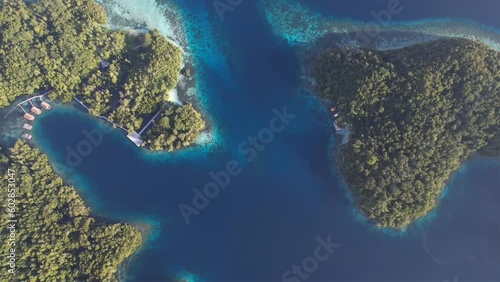 View from top on two green tropical islands, blue waters, coral reefs and small resort in Yangeffo, Raja Ampat, Papua, Indonesia photo