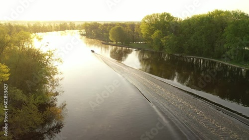 Aerial view of a fishing boat on the Wolf River in Fremont, Wisconsin known as the white bass capital of the world.  Sunny, sunrise, sunlight