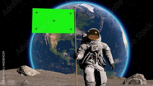 Lunar astronaut walks on the moon with green screen flag, placing a flag pole on the Moon surface, and salutes. You can track and add your flag with your logo. photo