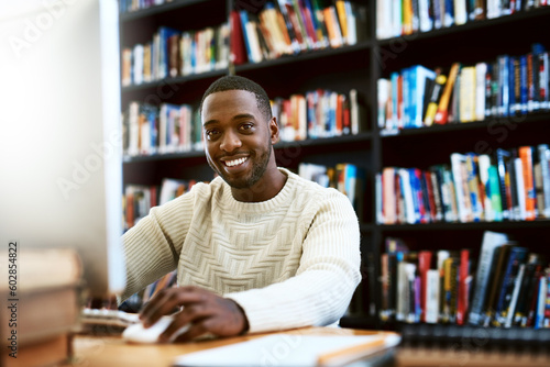Portrait, education and black man in a library, computer or research for a project, assignment or search website for information. Face, male person or student with technology, knowledge or connection