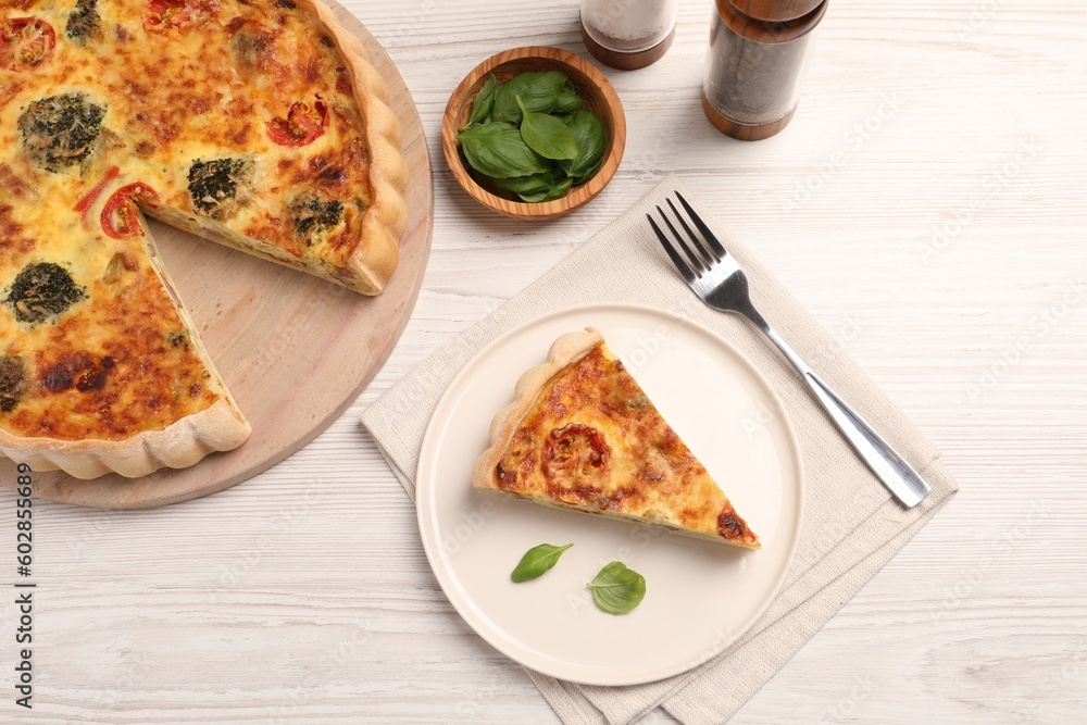 Delicious homemade vegetable quiche, basil leaves and fork on white wooden table, flat lay Delicious homemade vegetable quiche, basil leaves and fork on white wooden table, flat lay