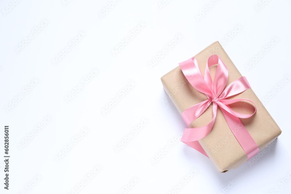 Beautiful gift box with pink bow on white background, top view. Space for text Beautiful gift box with pink bow on white background, top view. Space for text