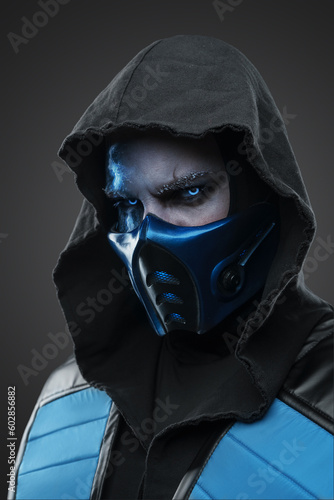 Portrait of Ice ninja with scar dressed in costume with hood staring at camera.