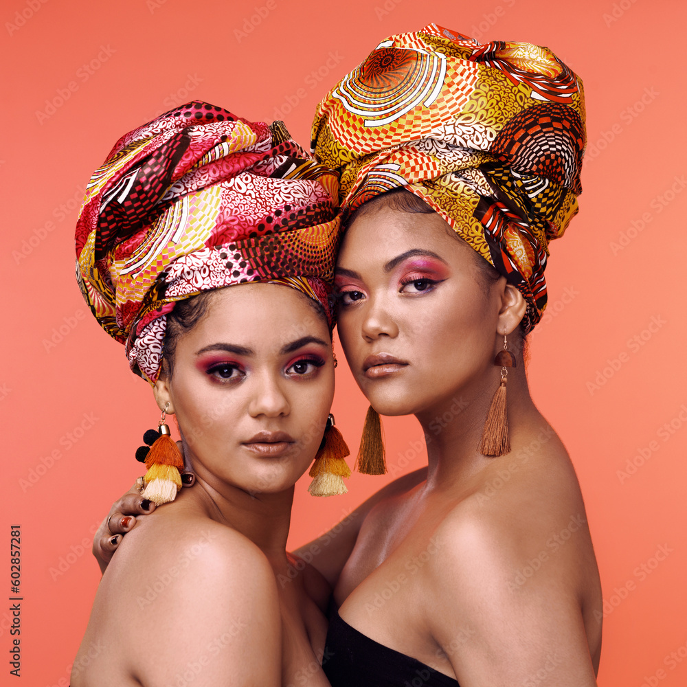 Obraz premium African fashion, makeup and portrait of women on orange background for cosmetics, beauty and accessory. Glamour, designer and face of female people in exotic jewelry, luxury style and scarf in studio