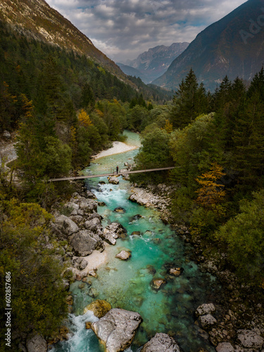 Foot bridge over Soča river with mountains in the background. Soča, Slovenia